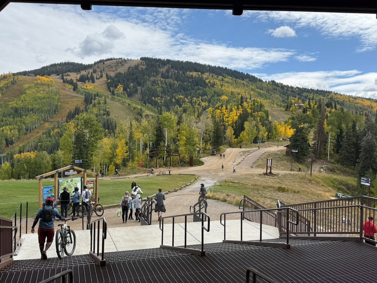 Riders heading out from the Steamboat base area, with aspens turning yellow on the mountain